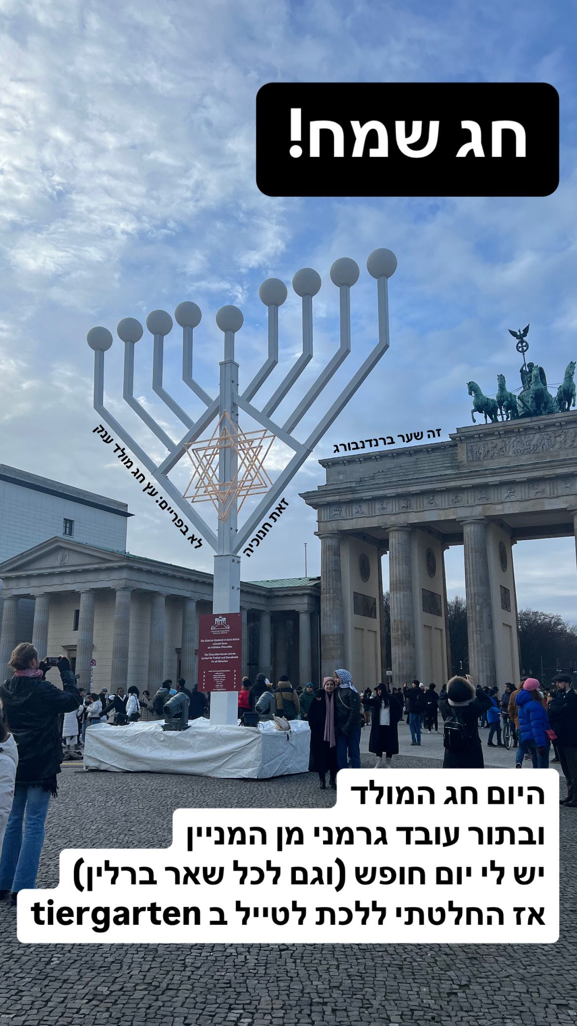 שער ברנדנבורג בברלין בשעת בין ערביים סגרירית (בחורף זה אומר בסביבות 13:00). מולו עומדת חנוכיה ענקית כזאת של בית חב״ד ומסביב הרבה אנשים. כיתוב: חג שמח! היום חג המולד ובתור עובד גרמני מן המניין יש לי יום חופש (וגם לכל שאר ברלין) אז החלטתי לטייל ב tiergarten. לא בפריים: עץ חג מולד ענק
