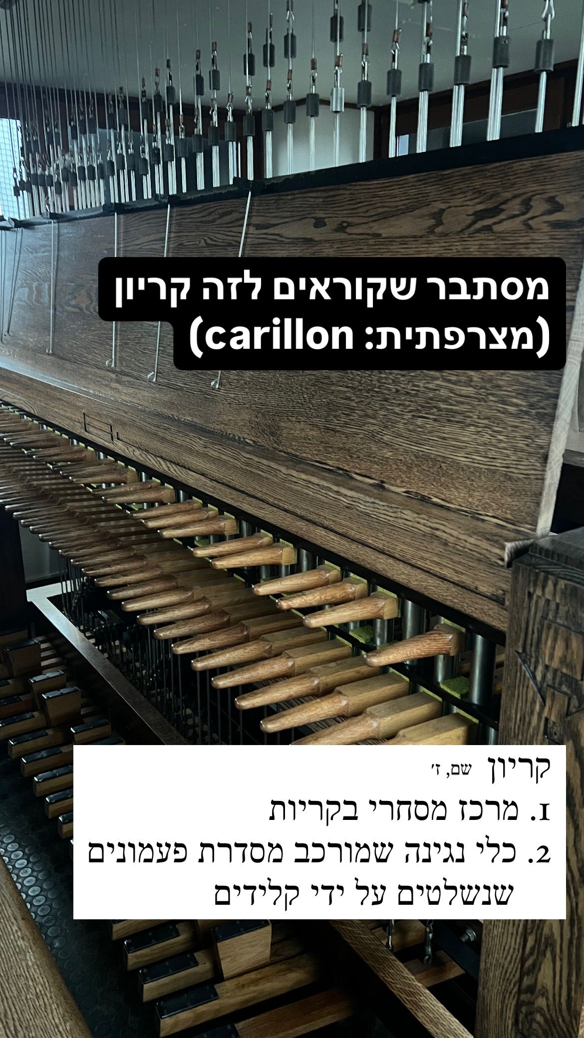 כלי נגינה שנראה כמו פסנתר אבל במקום קלידים רגילים יש ידיות אופקיות מרווחות. כיתוב: מסתבר שקוראים לזה קריון (מצרפתית: carillon). בתחתית התמונה מופיעה הגדרה מילונית לקריון, שם עצם, זכר: 1. מרכז מסחרי בקריות. 2. כלי נגינה שמורכב מסדרת פעמונים שנשלטים על ידי קלידים